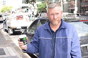 man holding UBET advertised coffee cup