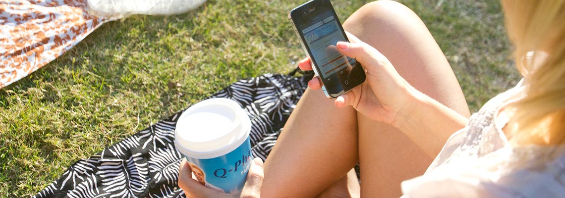 university girl taking action to coffee cup advertising on phone