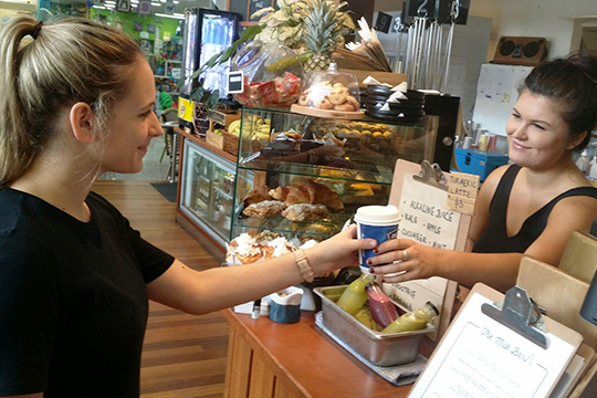 barista handing bcf advertisied coffee cup to customer