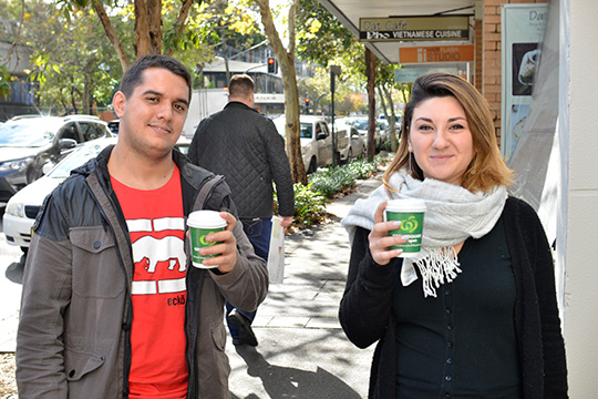 man and lady holding woolworths green square coffee cup